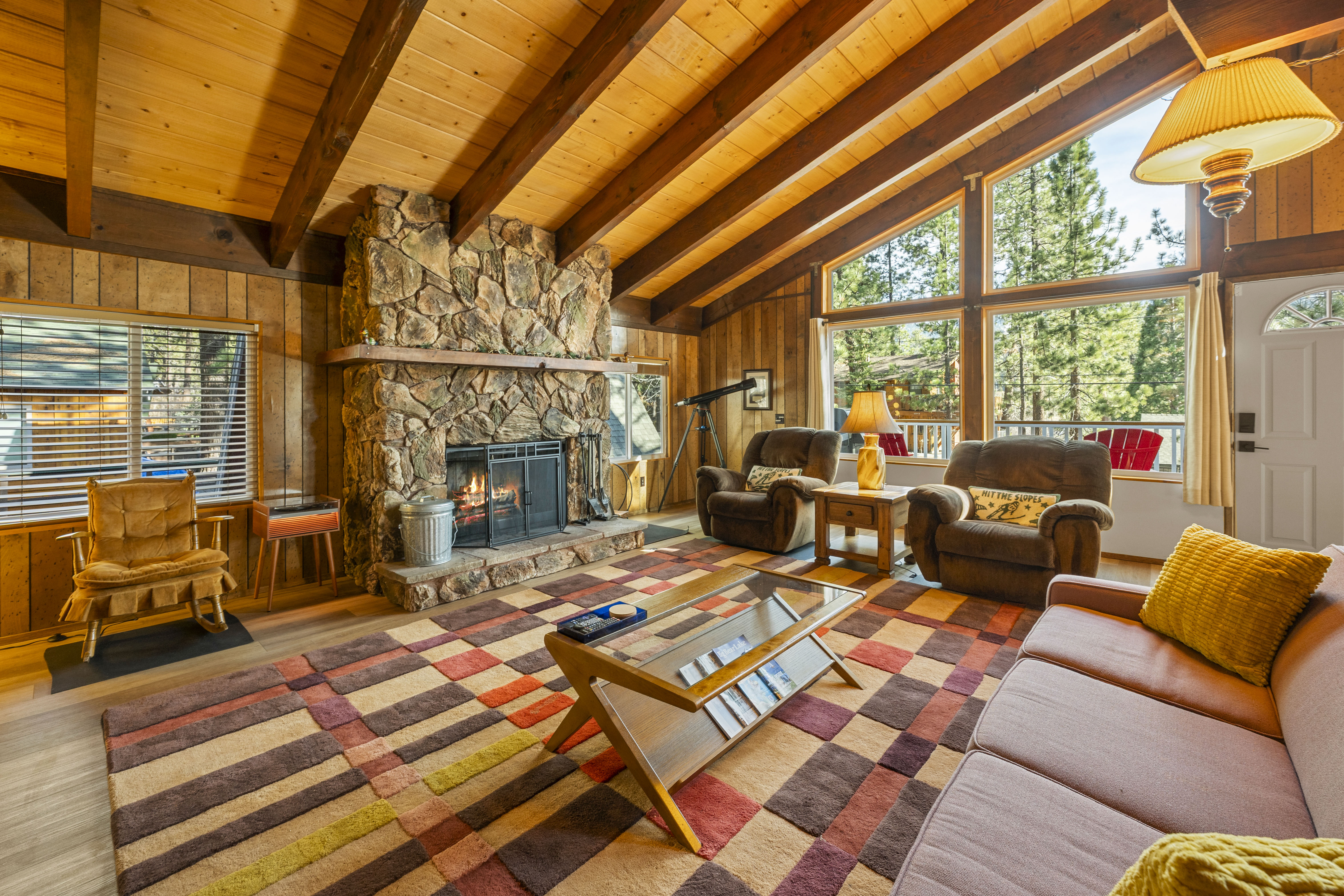 Warm cabin living room with stone fireplace